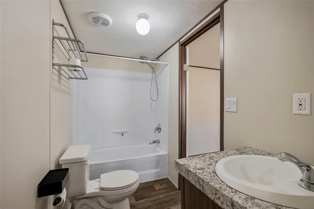 a bathroom with a granite countertop sink toilet and shower