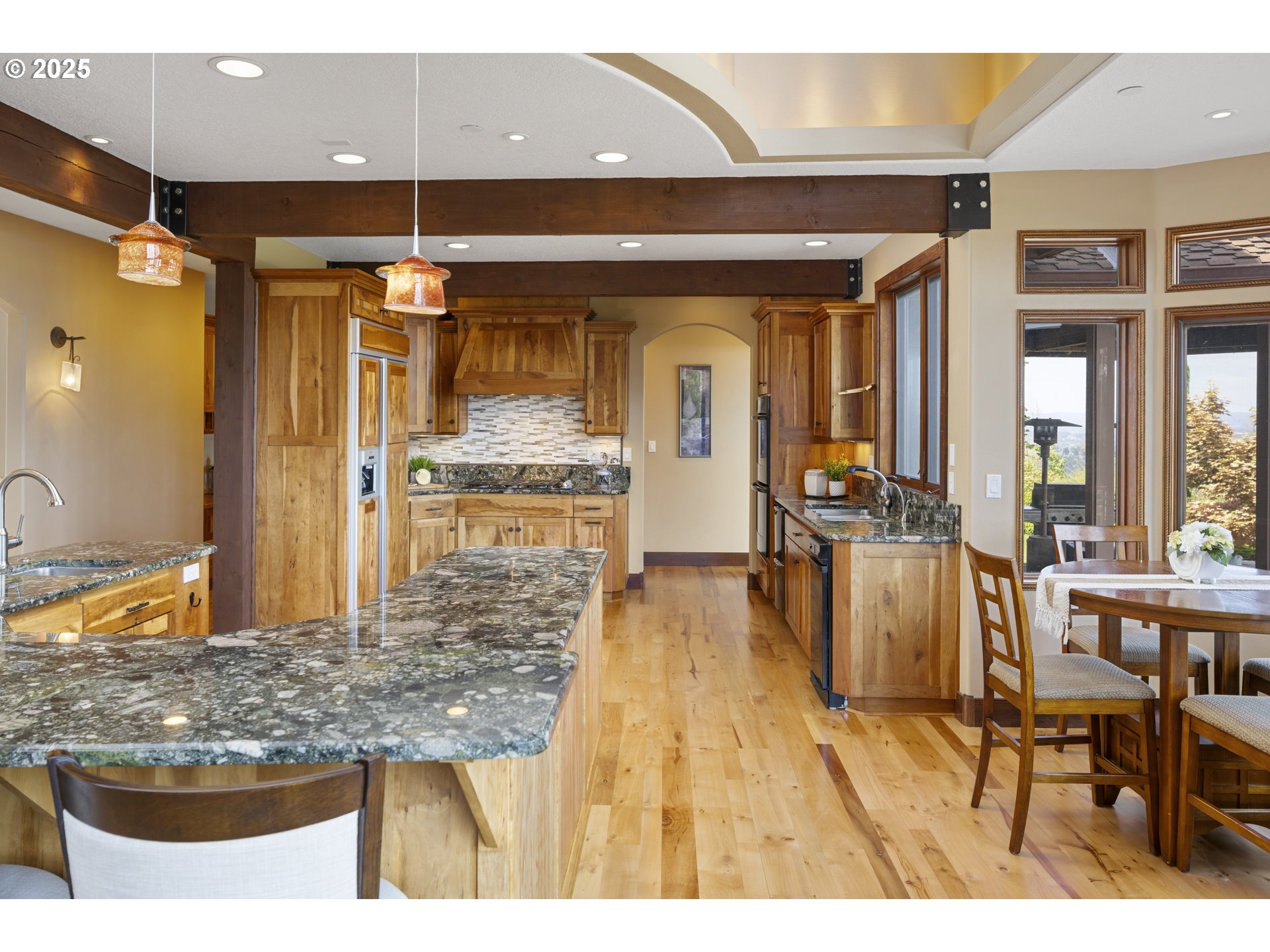 21250 Southwest Jaquith Road Newberg, OR 97132 - Photo 12 of 48 a kitchen with stainless steel appliances kitchen island granite countertop a table and chairs in it