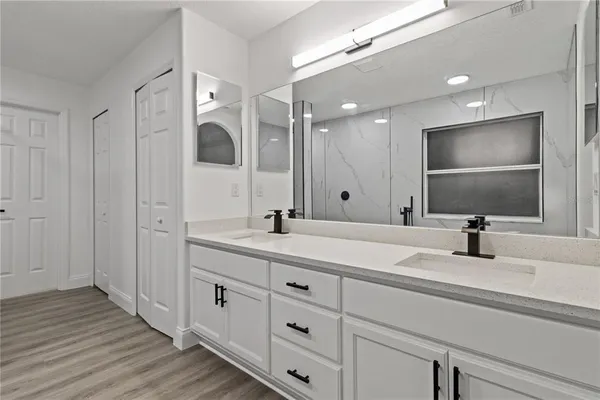 a bathroom with double vanity sinks and a large mirror