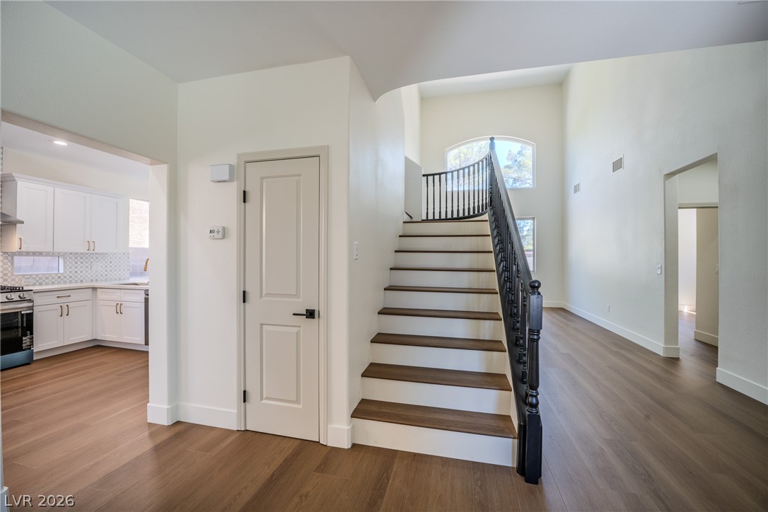 1832 Spring Summit Lane Las Vegas, NV 89134 - Photo 10 of 52 A grand entrance welcomes you with a gracefully curving staircase, connecting living spaces with architectural elegance.