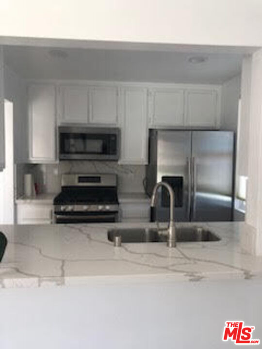 4510 Antigua Way Oxnard, CA 93035 - Photo 3 of 12 a kitchen with a refrigerator and a sink