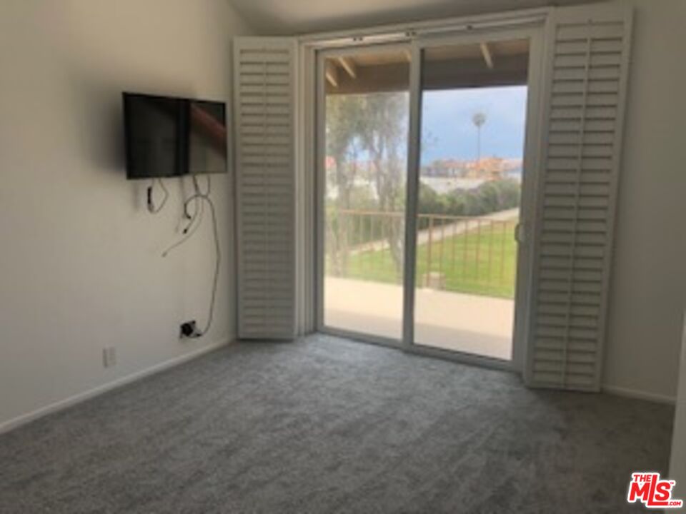 4510 Antigua Way Oxnard, CA 93035 - Photo 6 of 12 a view of an empty room with a flat screen tv and a window