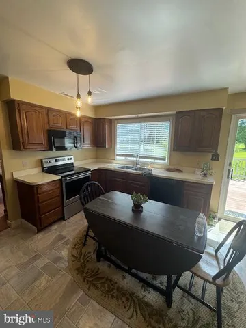 a kitchen with a table chairs microwave and cabinets