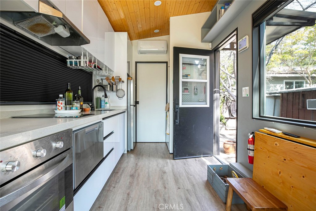 7553 McGroarty Street Tujunga, CA 91042 - Photo 24 of 38 a kitchen with stainless steel appliances granite countertop a refrigerator a sink dishwasher a stove and white countertops with wooden floor