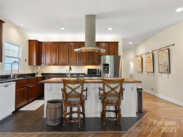 a kitchen with stainless steel appliances kitchen island granite countertop a stove a sink and a microwave