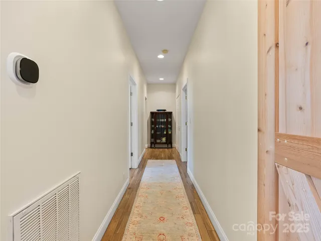 a view of a hallway with wooden floor