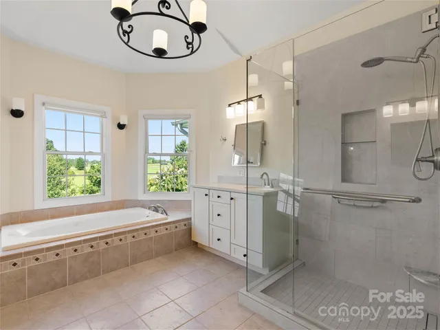 a bathroom with a double vanity sink mirror and bathtub