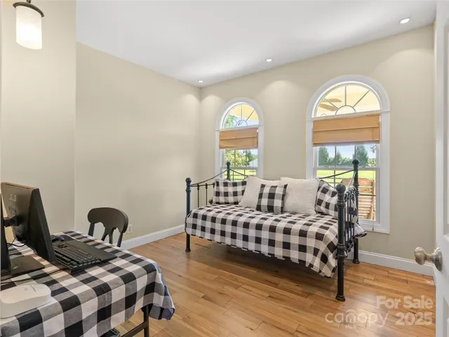 a bedroom with a bed a lamp and a large window