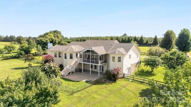 an aerial view of a house with swimming pool and sitting area
