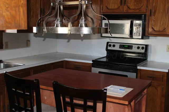 a kitchen with stainless steel appliances a stove a microwave and wood cabinets