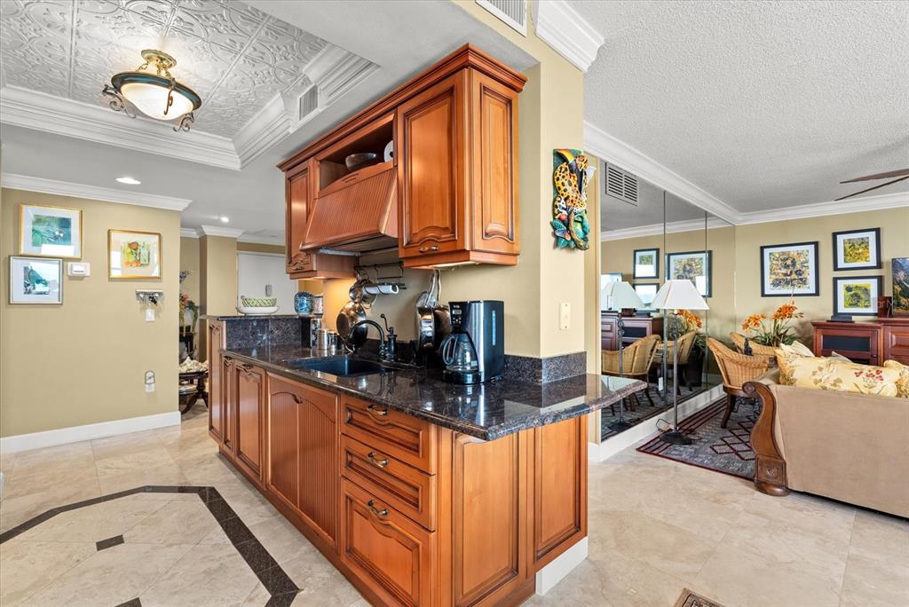 1000 Longboat Club Road, Unit 1001 Longboat Key, FL 34228 - Photo 12 of 40 a kitchen with stainless steel appliances granite countertop a sink stove and wooden cabinets