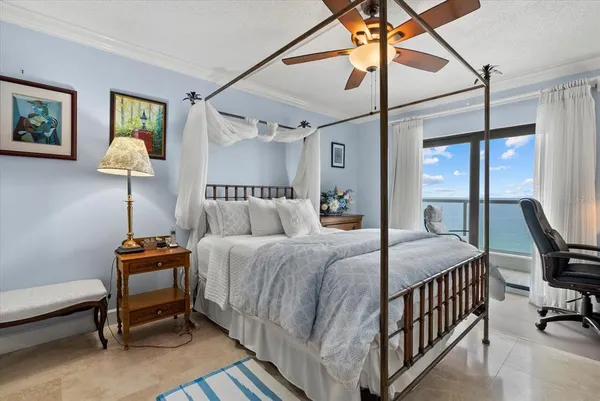 a bedroom with a bed a desk and chair with the potted plants
