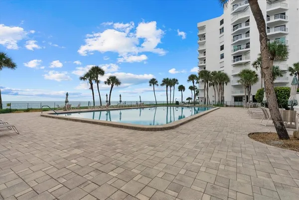 a view of a swimming pool with a lawn chair and tables