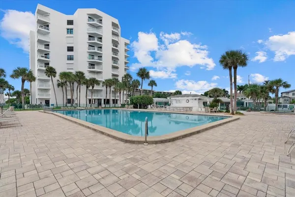 a view of a multi story residential apartment building with a yard