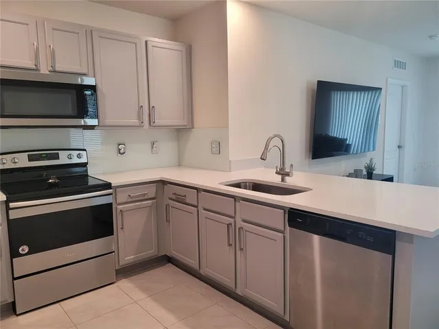 a kitchen with stainless steel appliances granite countertop a sink stove and microwave