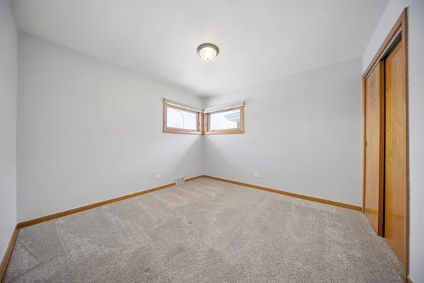 an empty room with windows and painted walls