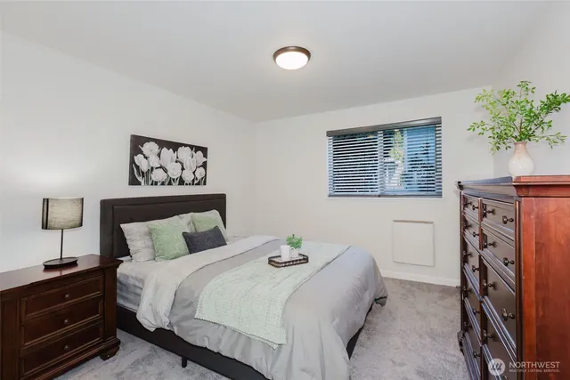 a bedroom with a bed and painting on the wall