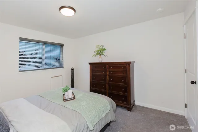 a bedroom with a bed and a potted plant