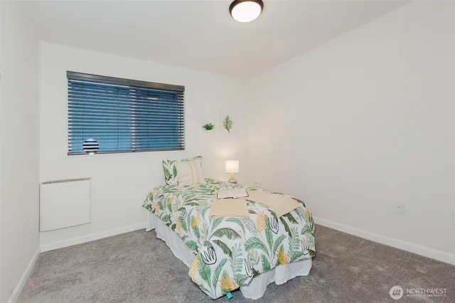 a bedroom with a bed and a wall painting