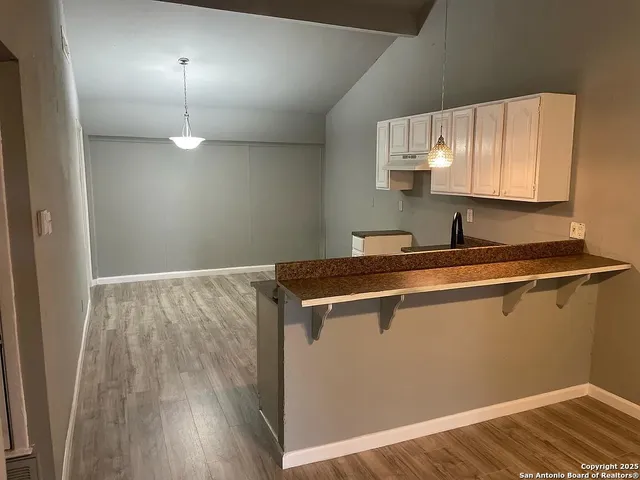 a room with a sink a mirror and lamp