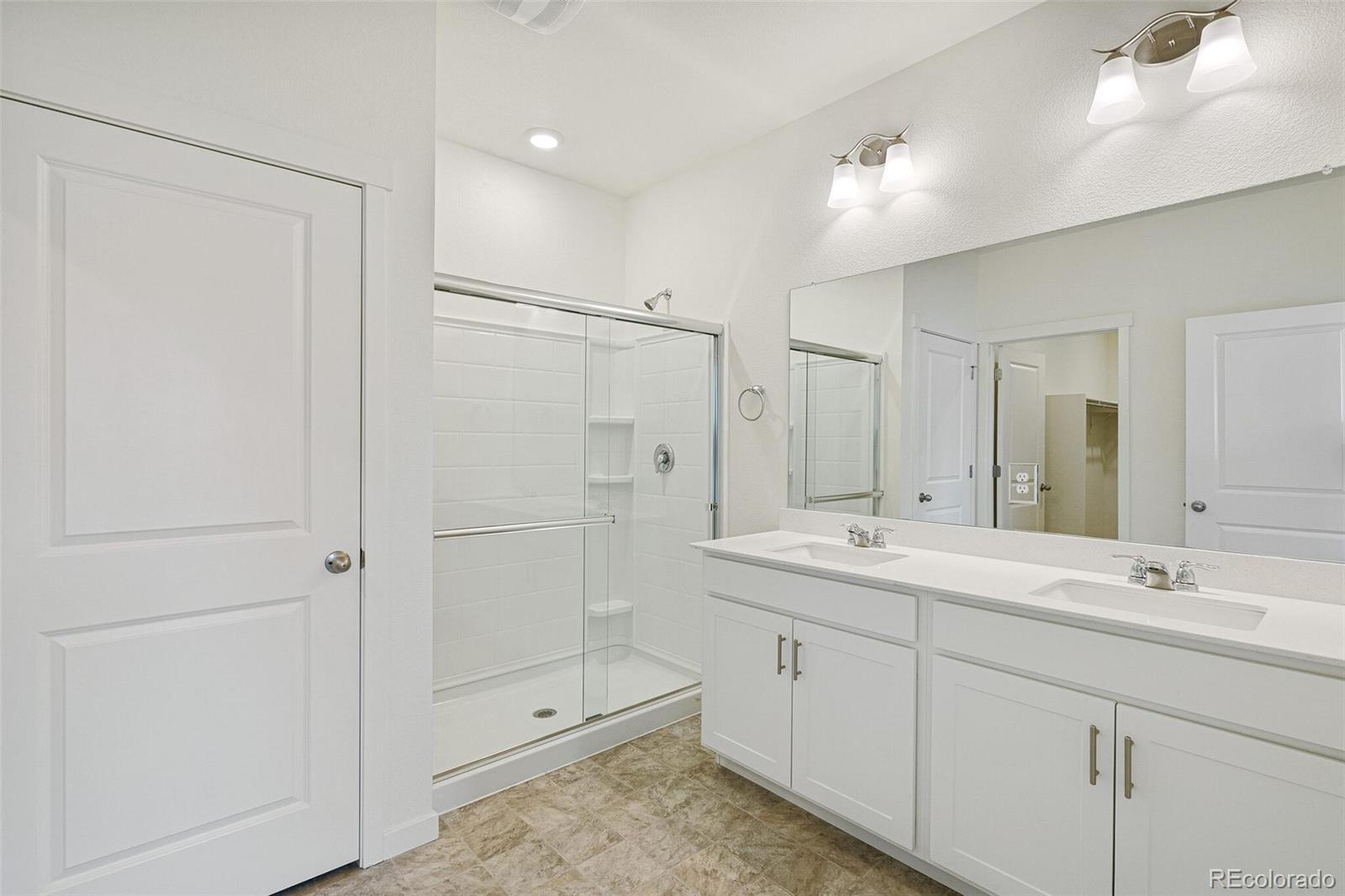 522 Twilight Court Fort Lupton, CO 80621 - Photo 20 of 29 a spacious bathroom with a shower sink and mirror