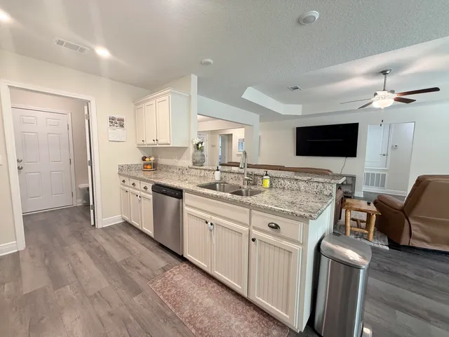 a kitchen with a sink stove and wooden floor