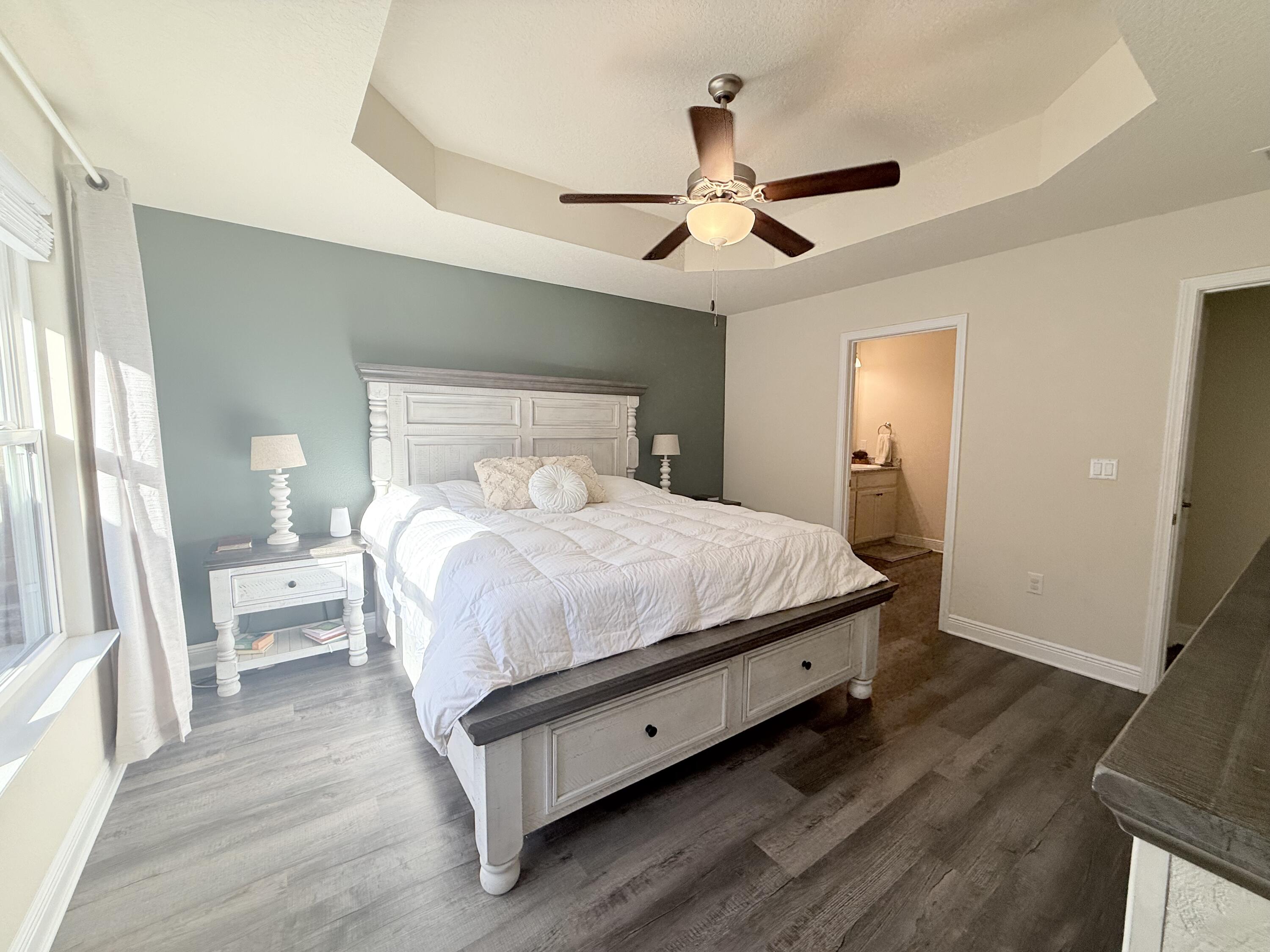 3315 Doyle Hawkins Road Navarre, FL 32566 - Photo 15 of 36 a bedroom with a large bed and a chandelier