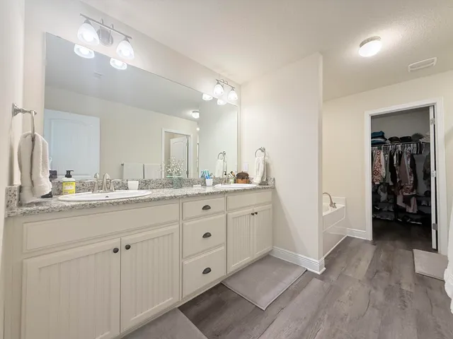 a spacious bathroom with a granite countertop sink mirror and a