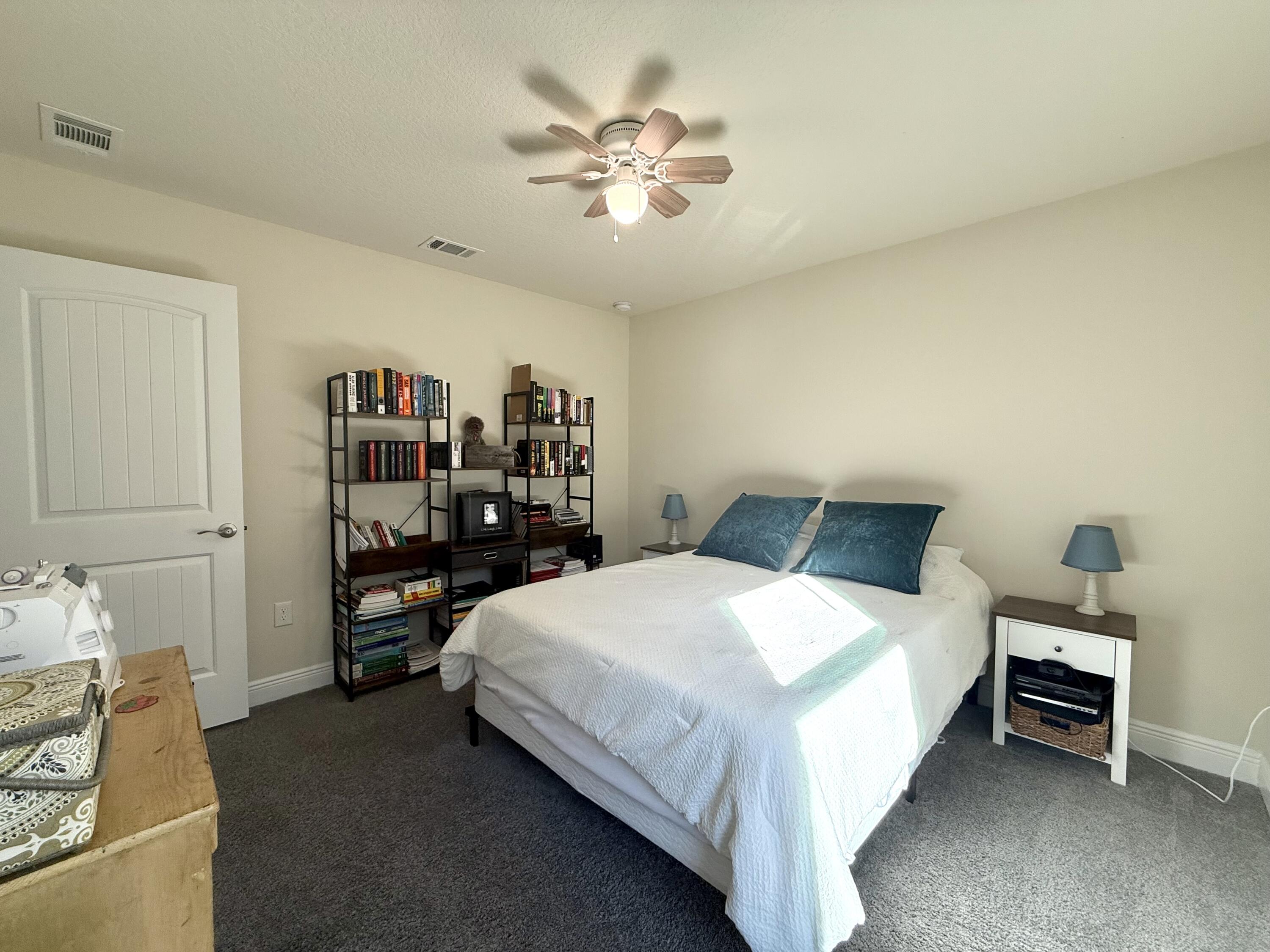 3315 Doyle Hawkins Road Navarre, FL 32566 - Photo 21 of 36 a bedroom with a bed and a chandelier