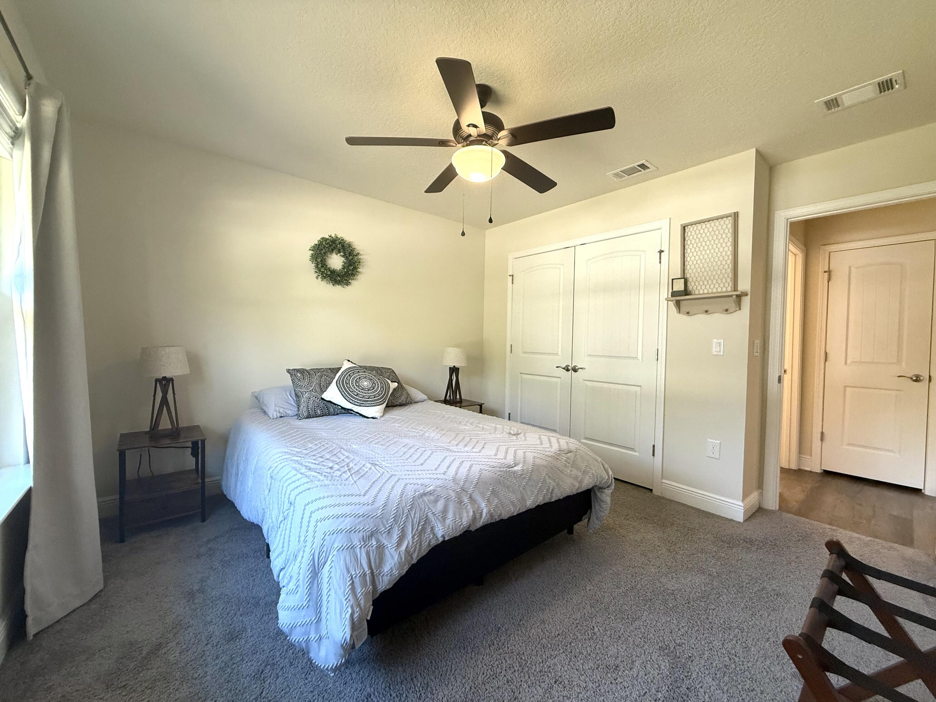 3315 Doyle Hawkins Road Navarre, FL 32566 - Photo 26 of 36 a spacious bedroom with a bed and a chandelier
