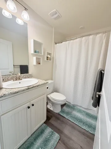 a bathroom with a granite countertop sink toilet and shower