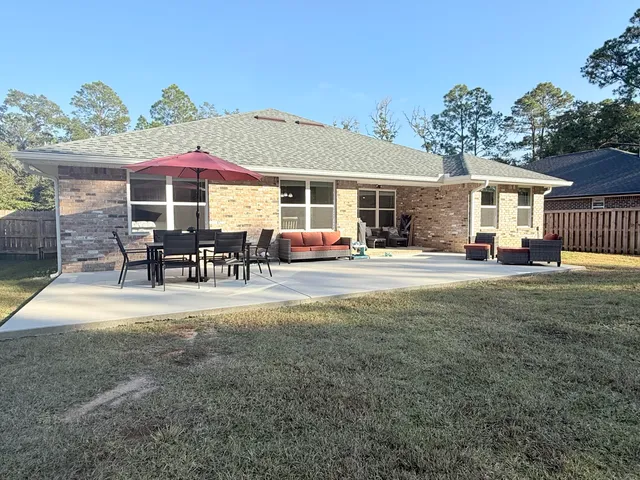 a patio with sofas fire pit table and chairs