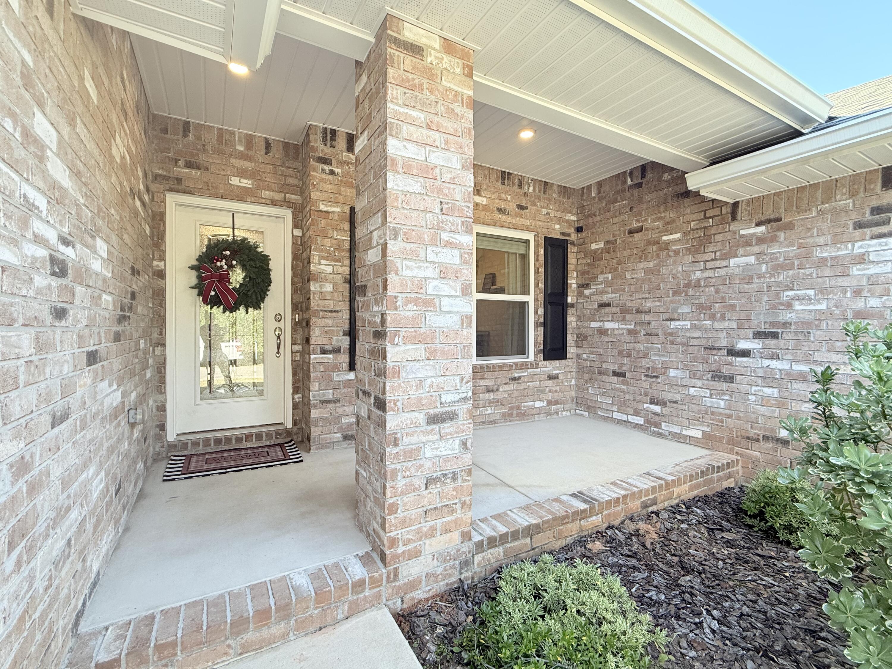 3315 Doyle Hawkins Road Navarre, FL 32566 - Photo 4 of 36 a bathroom with a granite countertop sink a mirror and shower