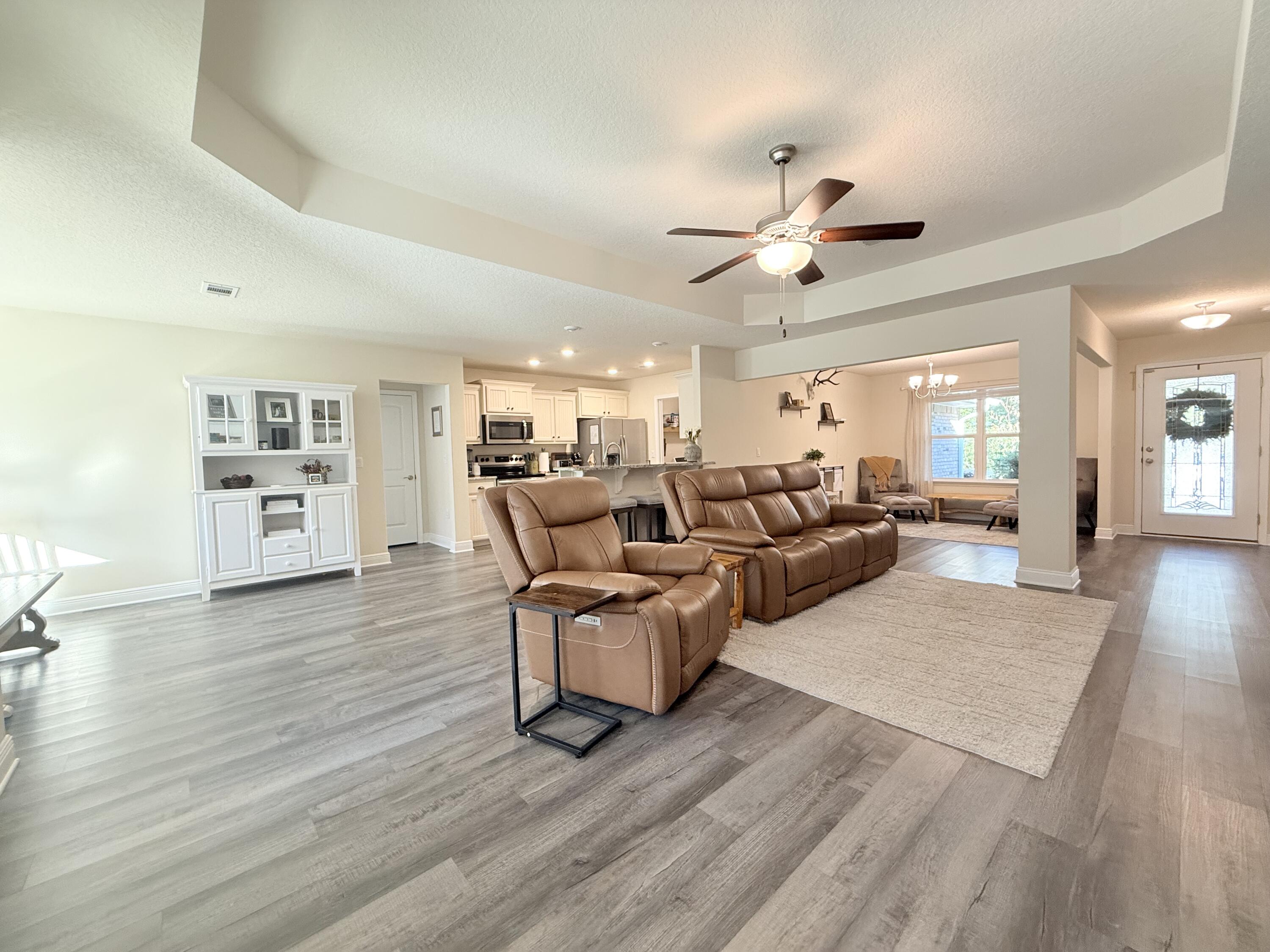 3315 Doyle Hawkins Road Navarre, FL 32566 - Photo 6 of 36 a living room with furniture and a wooden floor