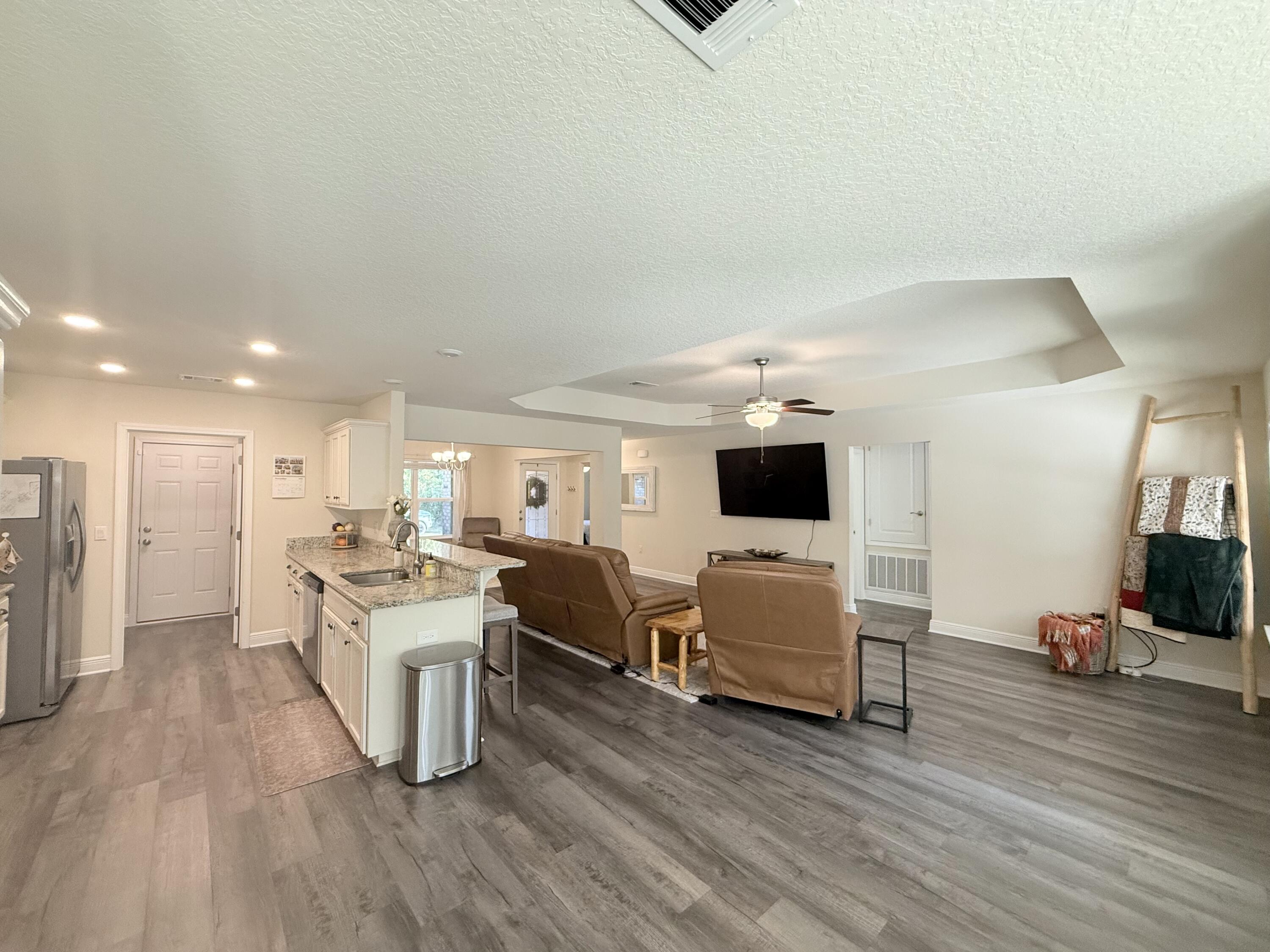 3315 Doyle Hawkins Road Navarre, FL 32566 - Photo 8 of 36 a living room with furniture and a wooden floor