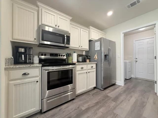 a kitchen with stainless steel appliances a stove a microwave and cabinets