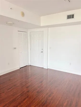 a view of an empty room with wooden floor