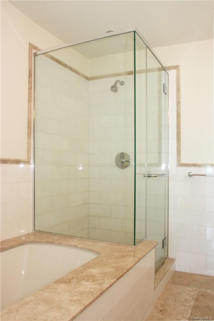 175 Huguenot Street, Unit 1405 New Rochelle, NY 10801 - Photo 11 of 20 a bathroom with a shower and a glass door