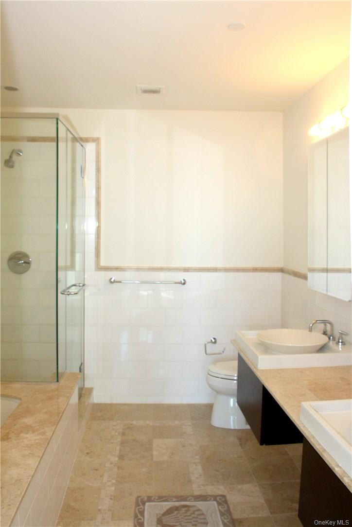 175 Huguenot Street, Unit 1405 New Rochelle, NY 10801 - Photo 12 of 20 a bathroom with a sink a toilet and shower