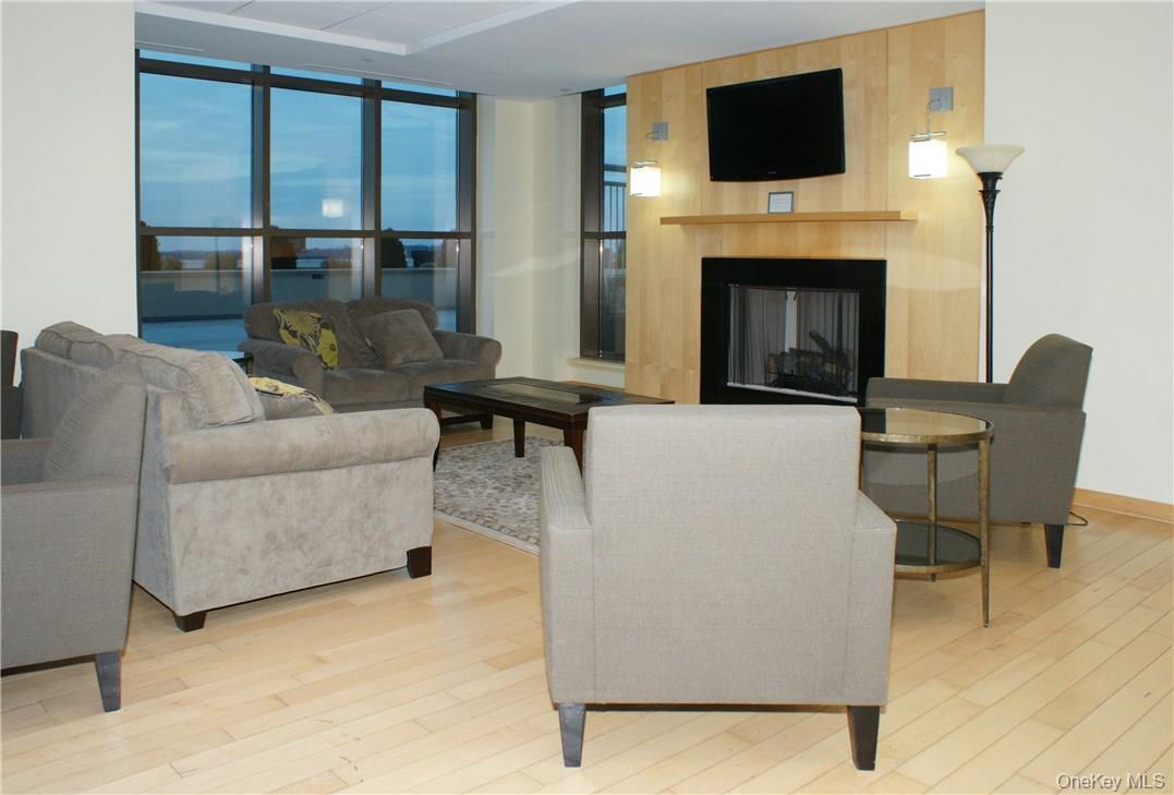 175 Huguenot Street, Unit 1405 New Rochelle, NY 10801 - Photo 16 of 20 a living room with furniture a fireplace and a flat screen tv