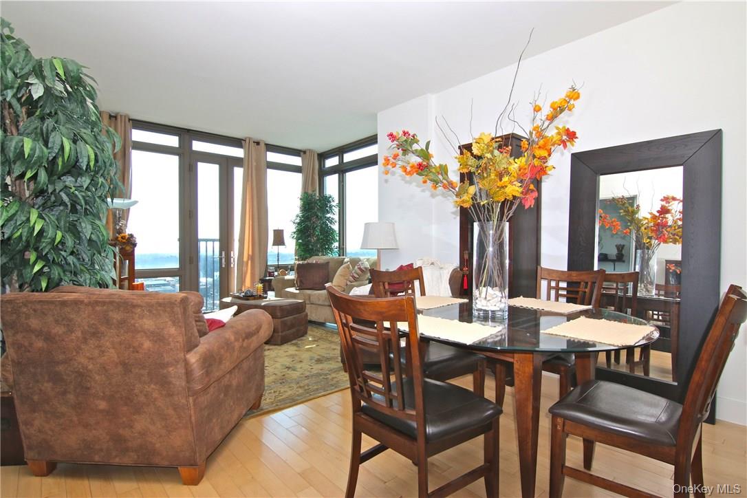 175 Huguenot Street, Unit 1405 New Rochelle, NY 10801 - Photo 7 of 20 a view of a dining room with furniture a chandelier and large windows