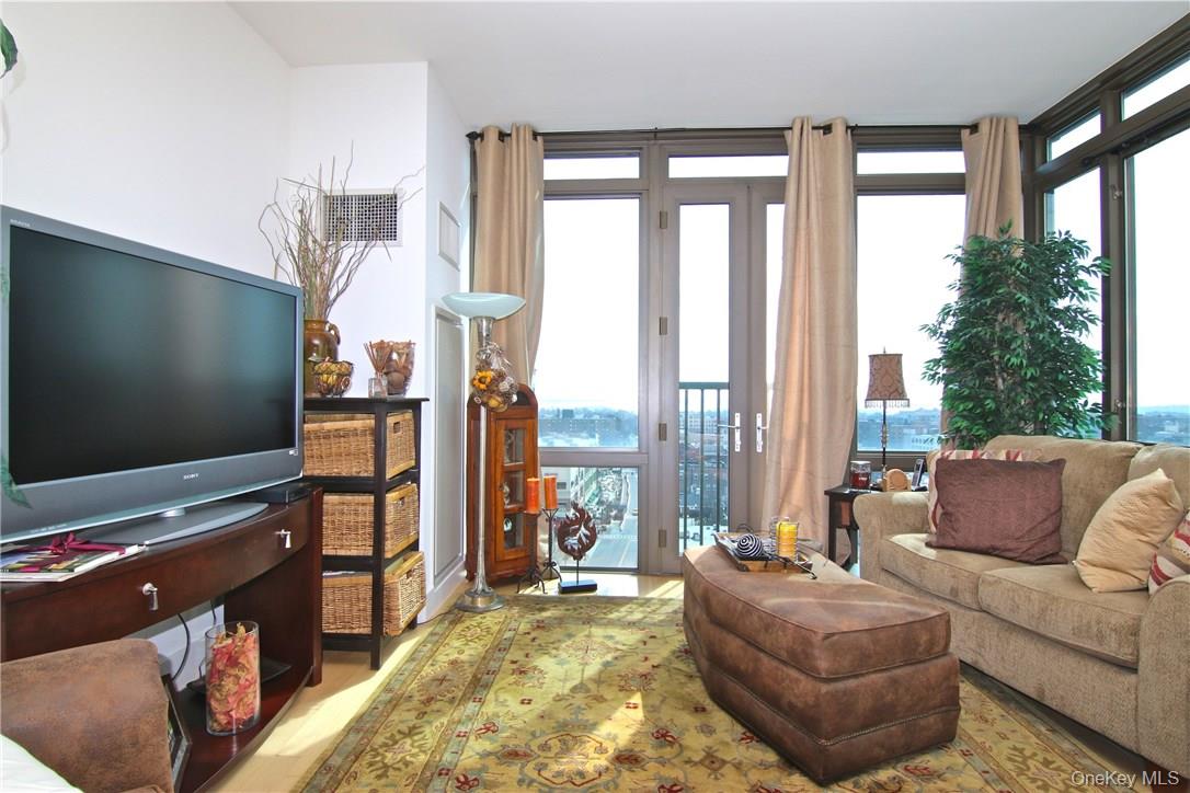175 Huguenot Street, Unit 1405 New Rochelle, NY 10801 - Photo 8 of 20 a living room with furniture and a flat screen tv