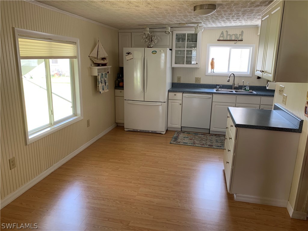 7775 Farrell Road Bokeelia, FL 33922 - Photo 10 of 33 a kitchen with stainless steel appliances a refrigerator a sink a stove a microwave and cabinets