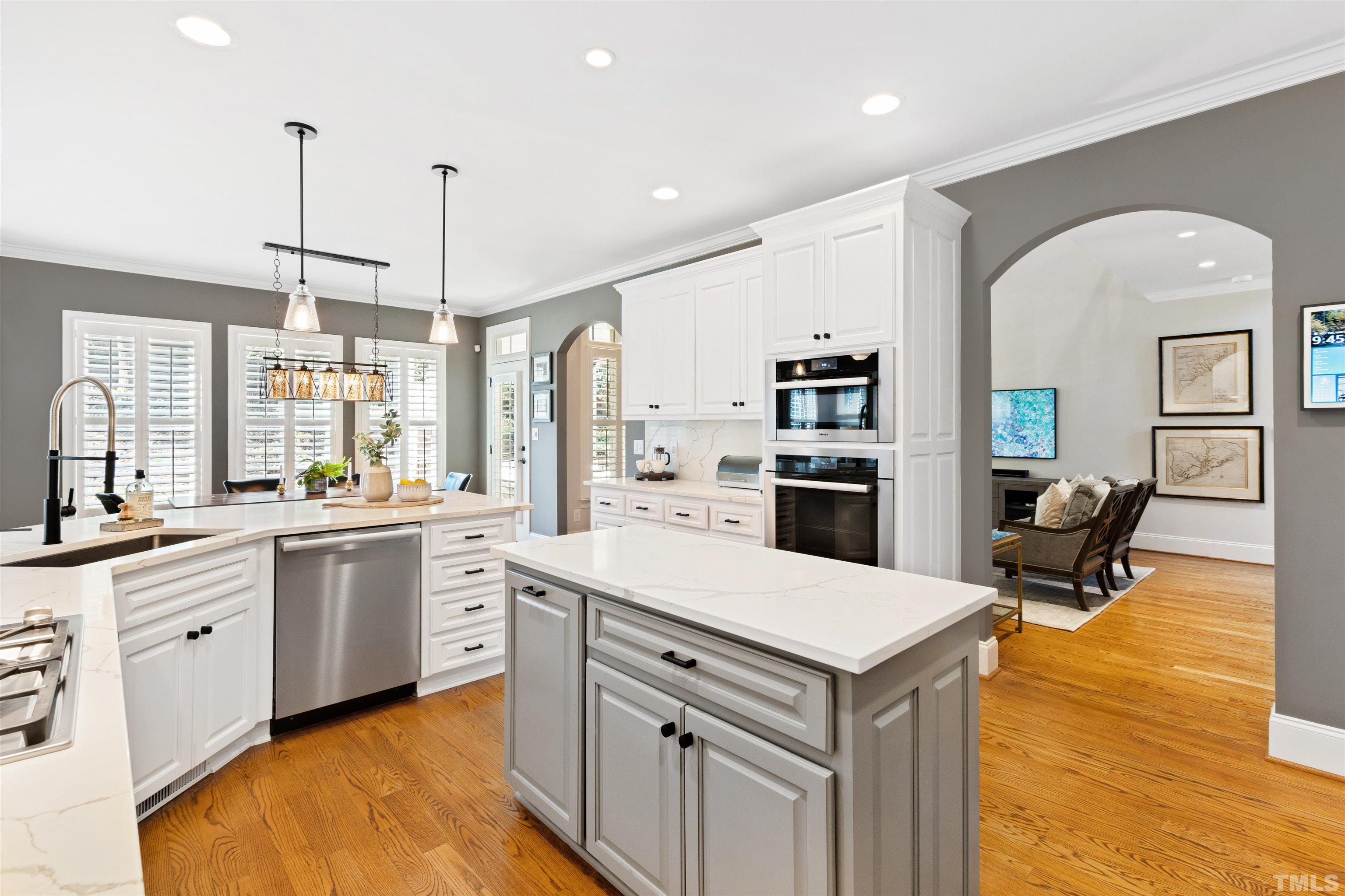 761 Wimbleton Drive Raleigh, NC 27609 - Photo 22 of 70 a kitchen with a refrigerator a sink dishwasher a oven and a dining table with wooden floor