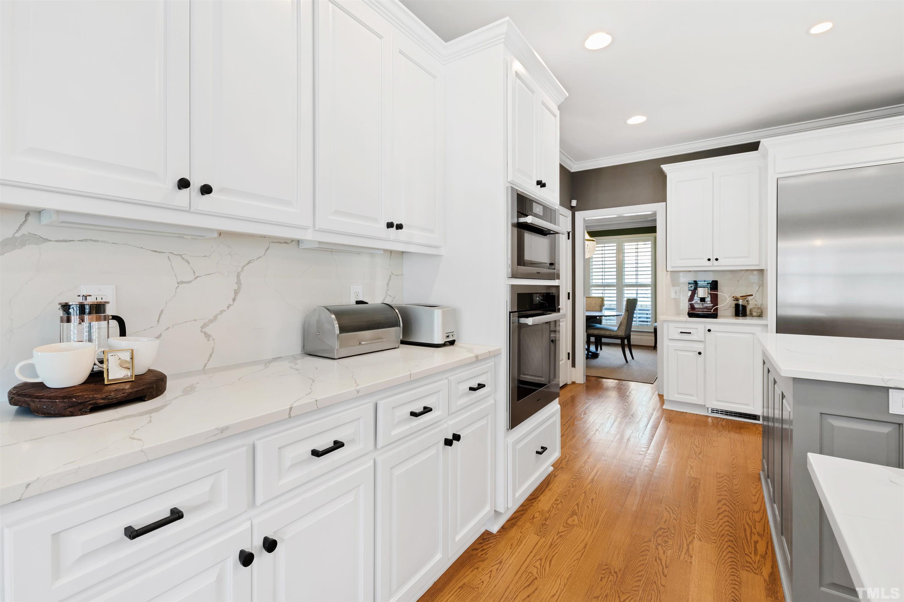 761 Wimbleton Drive Raleigh, NC 27609 - Photo 27 of 70 a kitchen with stainless steel appliances white cabinets and wooden floor