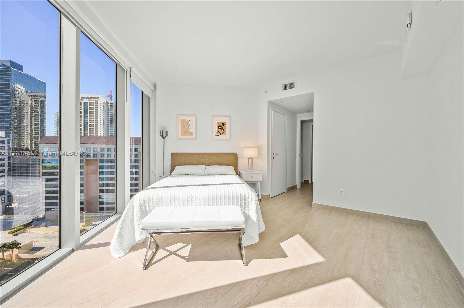1300 Brickell Bay Drive, Unit 1603 Miami, FL 33131 - Photo 16 of 32 a bedroom with a bed and a night stand