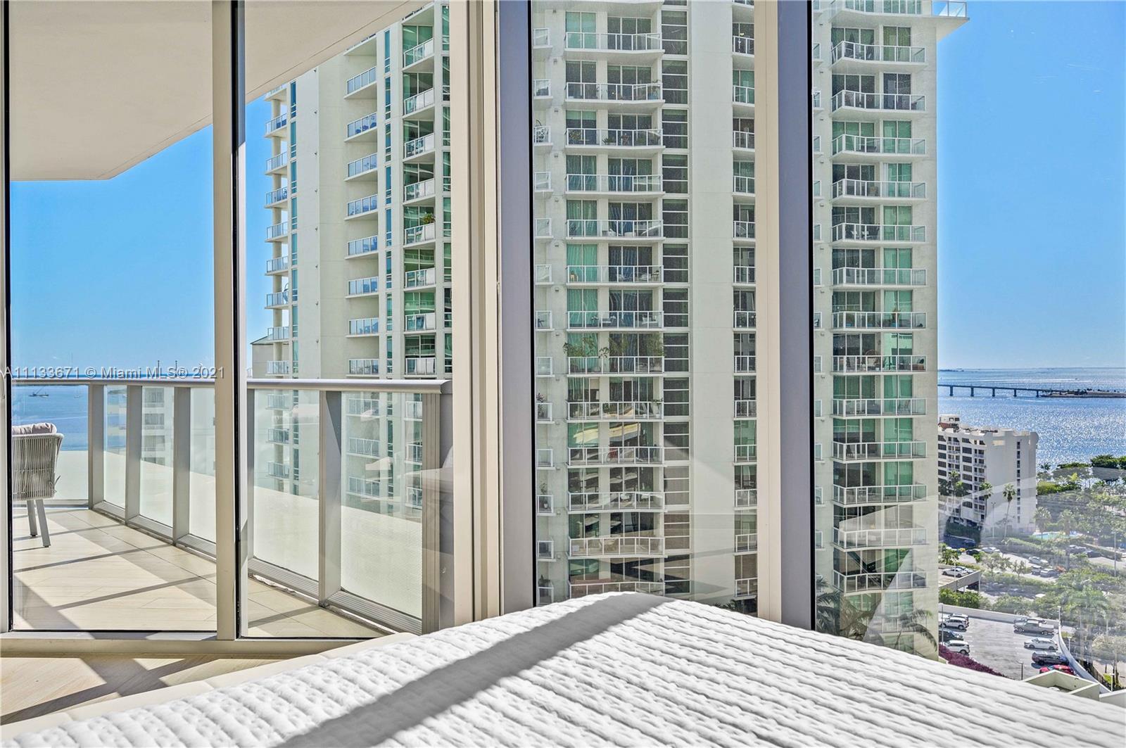 1300 Brickell Bay Drive, Unit 1603 Miami, FL 33131 - Photo 17 of 32 a bedroom with a bed and a mirror