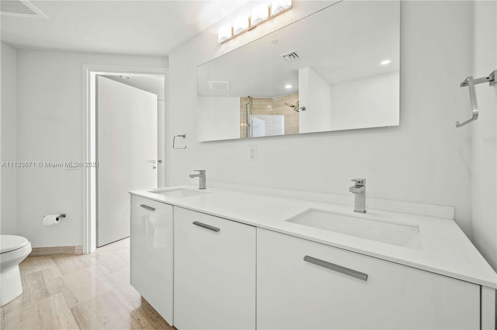 1300 Brickell Bay Drive, Unit 1603 Miami, FL 33131 - Photo 18 of 32 a bathroom with a sink a toilet and a mirror