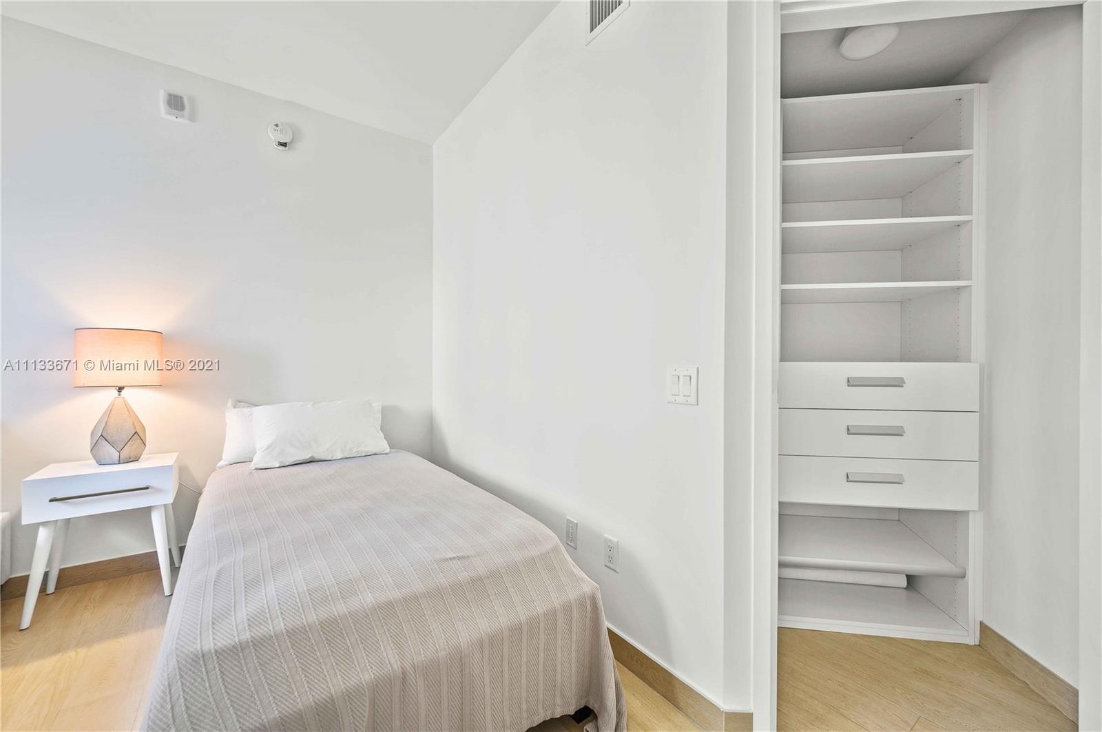 1300 Brickell Bay Drive, Unit 1603 Miami, FL 33131 - Photo 23 of 32 a bedroom with a bed and a lamp