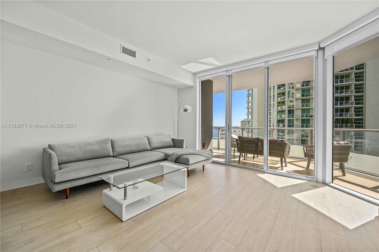 1300 Brickell Bay Drive, Unit 1603 Miami, FL 33131 - Photo 8 of 32 a living room with furniture and a floor to ceiling window